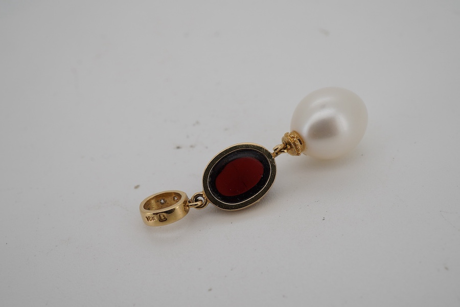 A modern 18k, cabochon garnet and cultured pearl set drop pendant, with two stone diamond set bale, approximately 30mm, gross weight 2.8 grams.